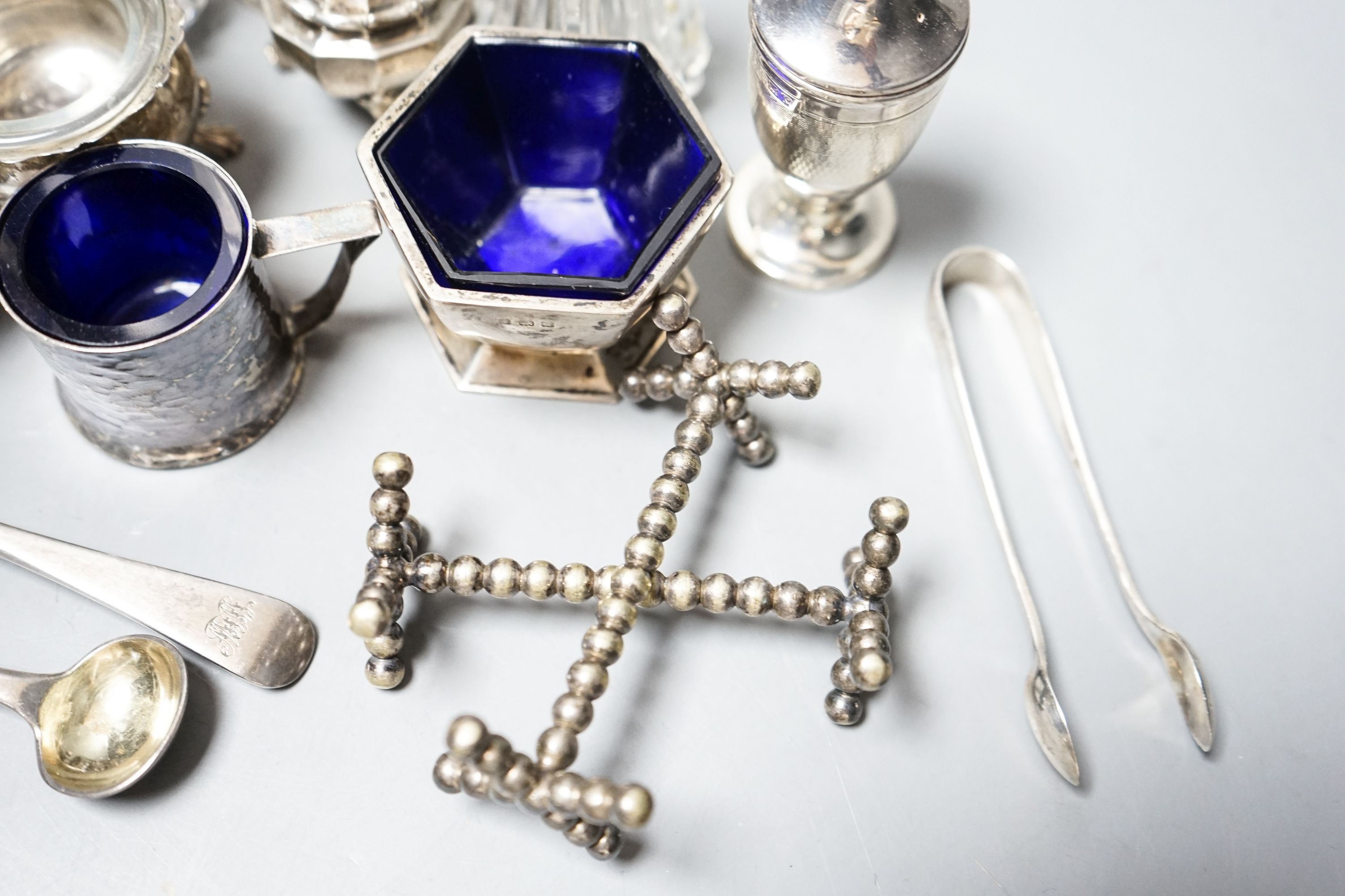 A group of small silver including condiments, match strike, cream jug, plated knife rests etc.